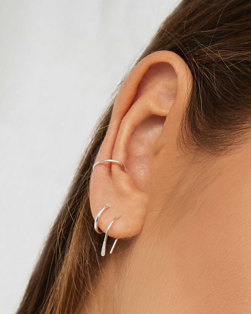 Model wears silver Arc Earrings, Mini Hoops and Fine Ear Cuff in multiple piercings